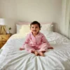 Pink stripe kids night suit sitting pose, cozy and breathable sleepwear