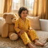 Kids yellow truck print winter night suit sitting pose, warm and comfortable sleepwear