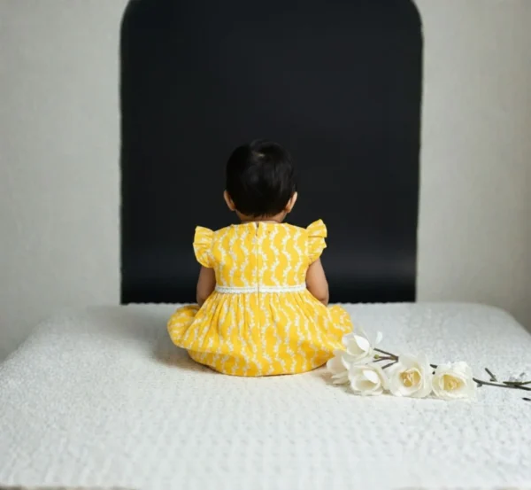 Yellow cotton infant frock back view, breathable and cozy baby outfit