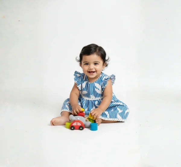 Blue cotton infant frock playing pose, cozy and lightweight baby clothing